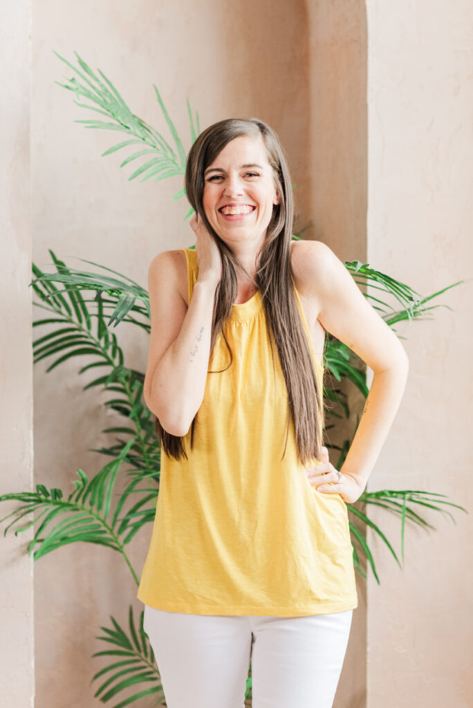 sandra has her hand in her hair as she laughs at the camera. photo is used in a blog post about wedding photographers with chronic illnesses
