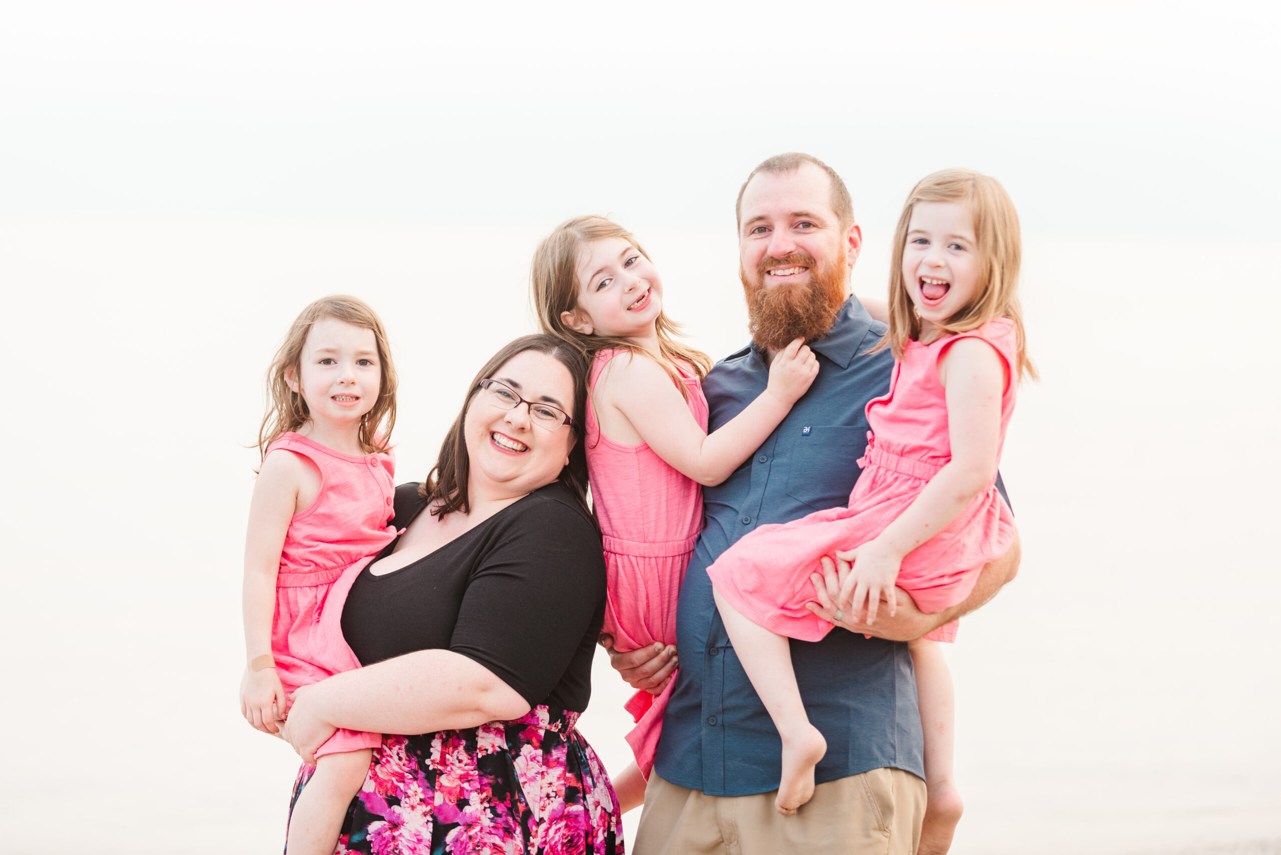 mom, dad, and three daughters smiling at the camera. photo is used in a blog post about starting a photography business.