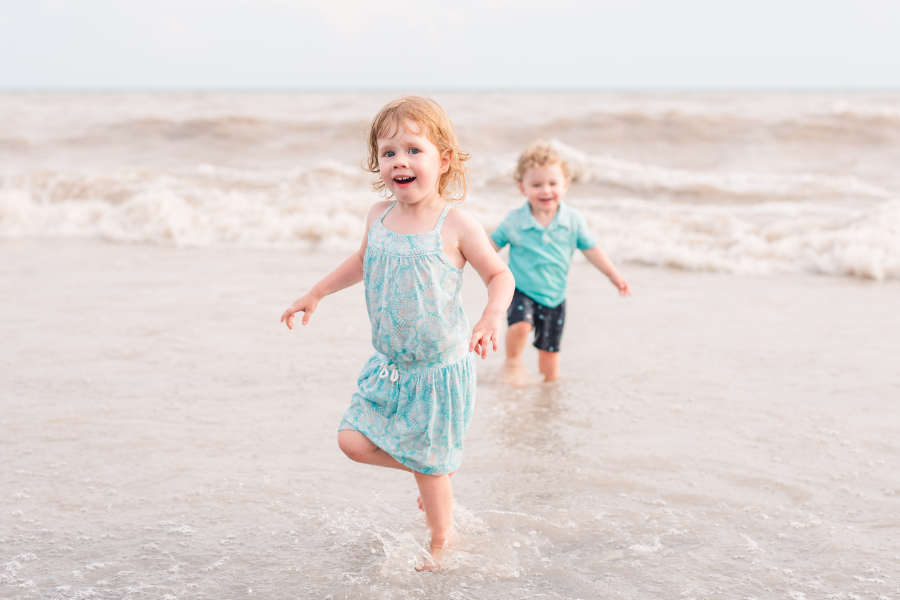 a little girl and little boy run away from a wave coming up behind them at the beach. photo is used in a blog post sharing show notes from the podcast Keeping It Candid