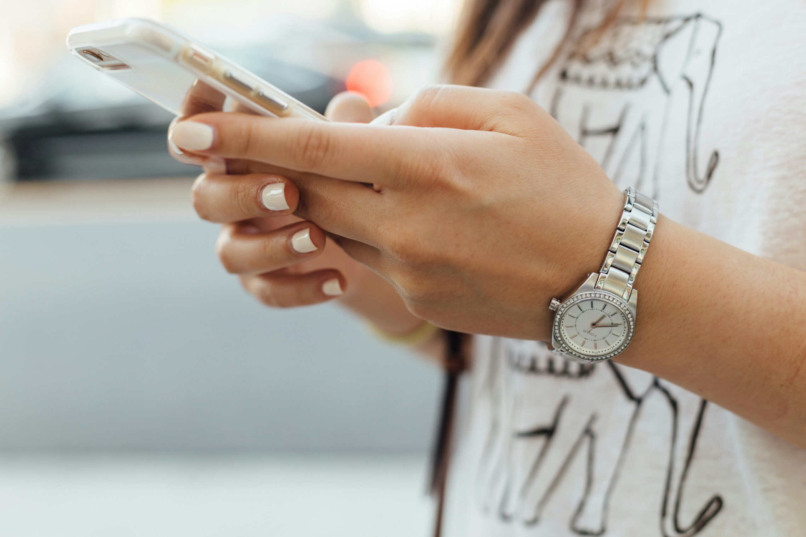 a woman holding her cell phone. used in a blog post about why photographers should use a crm mobile app