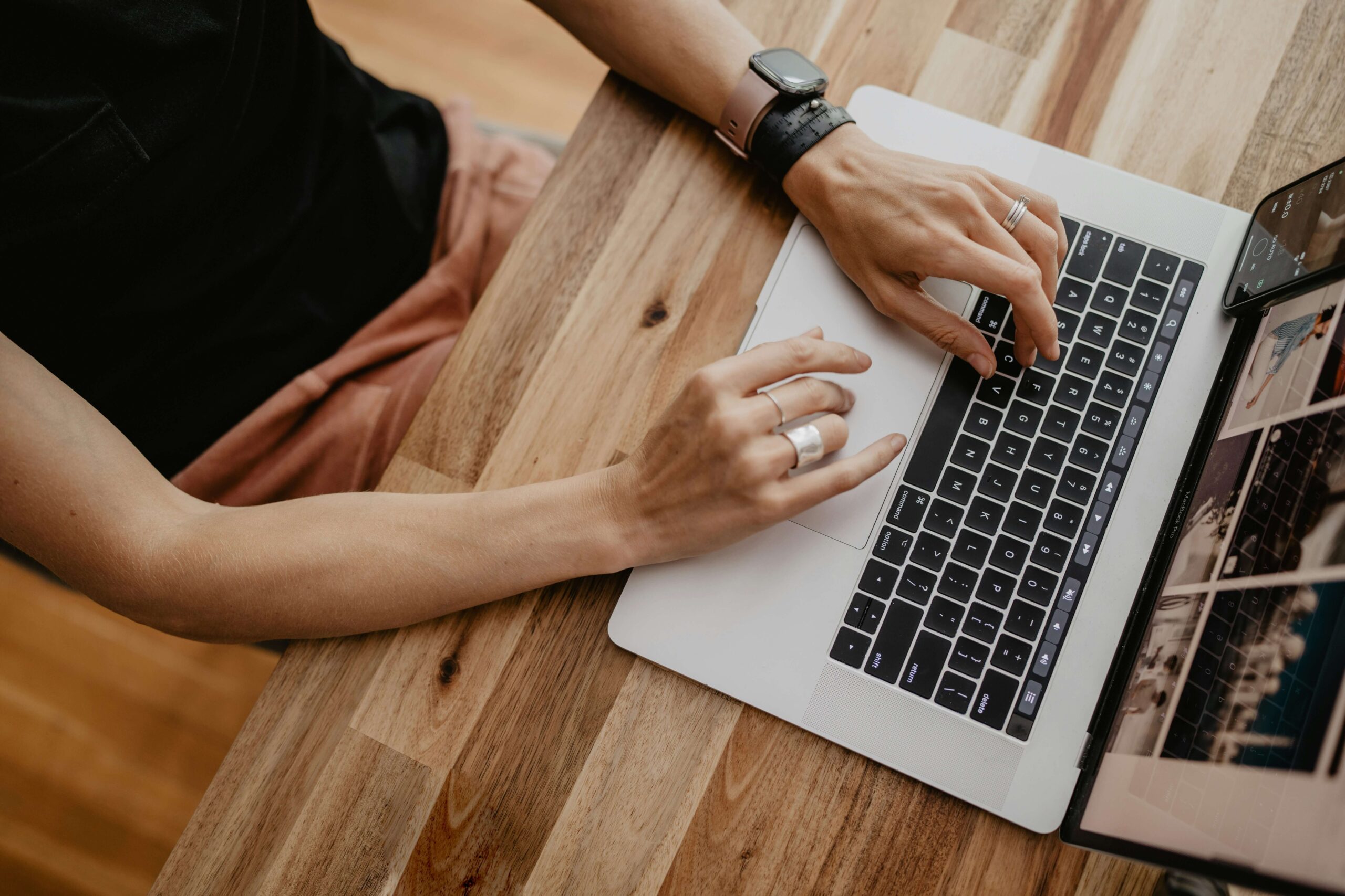 Wedding photographer working on a laptop to organize client workflows and HoneyBook systems for a smoother, burnout-free business.