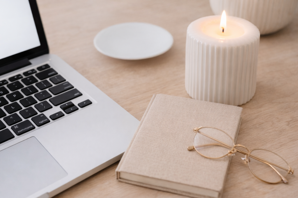 Close-up of a laptop and notebook on a calm home office desk, representing a thoughtful inquiry workflow setup.