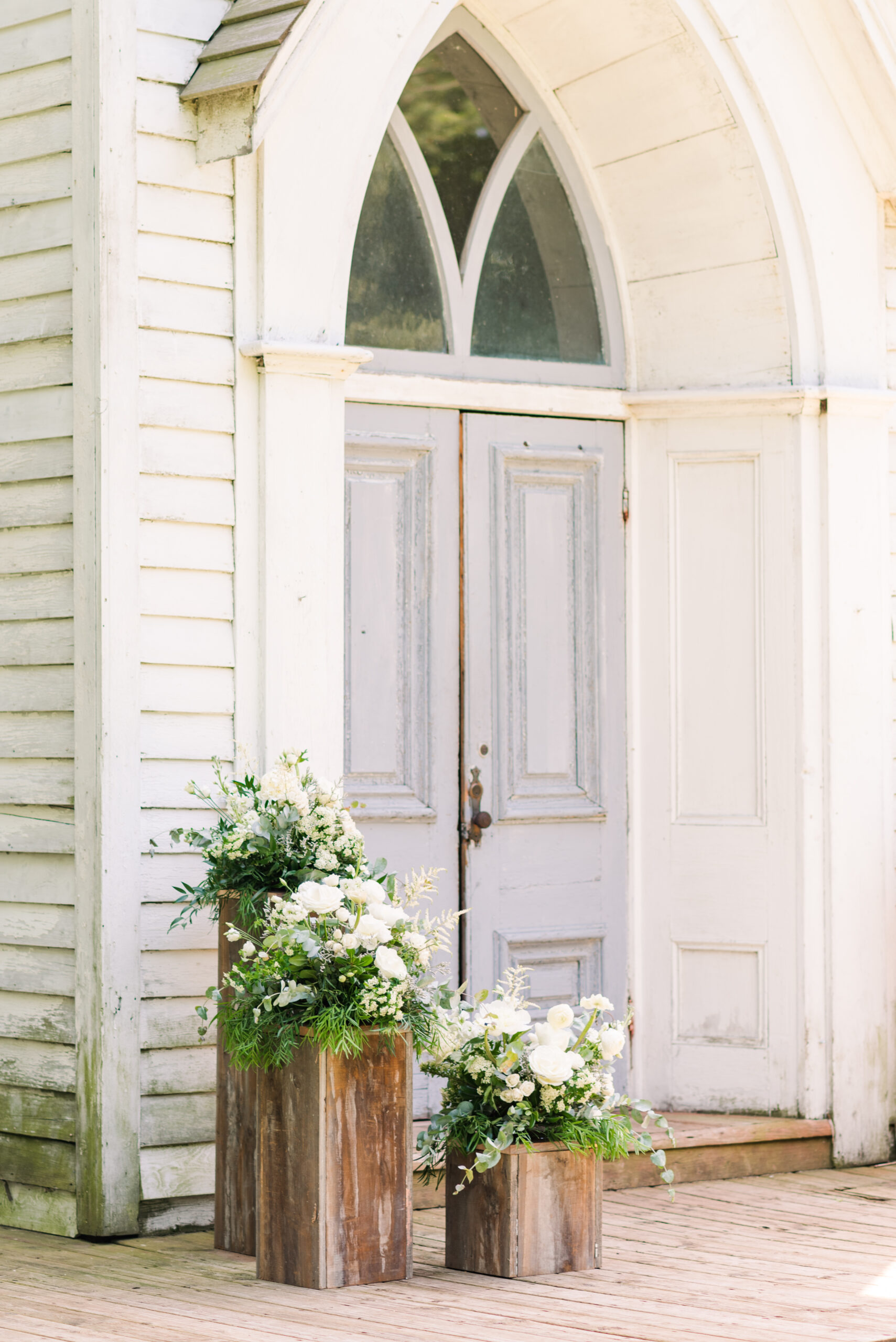 white flowers sit on top of three wooden pillars at cranberry creek gardens. photo by life is beautiful photography used in a blog post about wedding photography inquiries