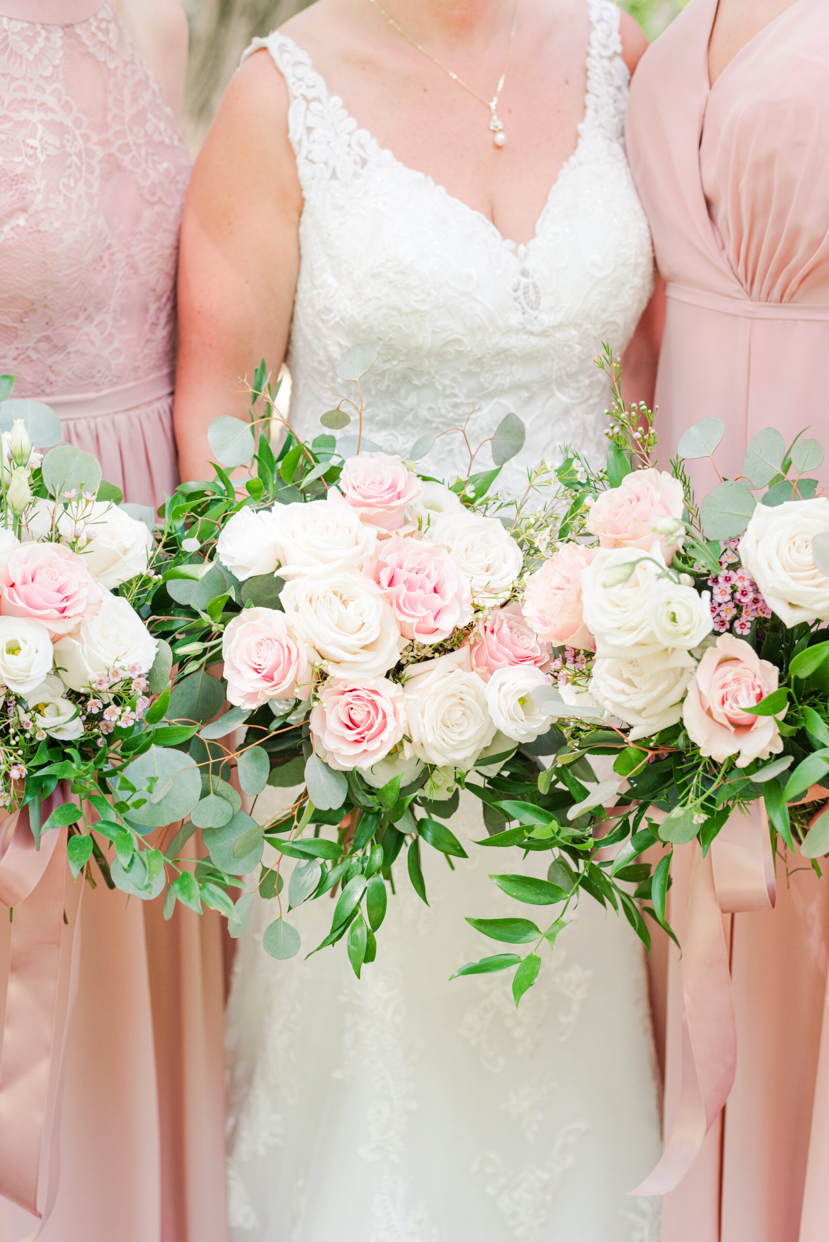 wedding bouquets being held by a bride and bridesmaids - used in a blog post about Honeybook for wedding photographers