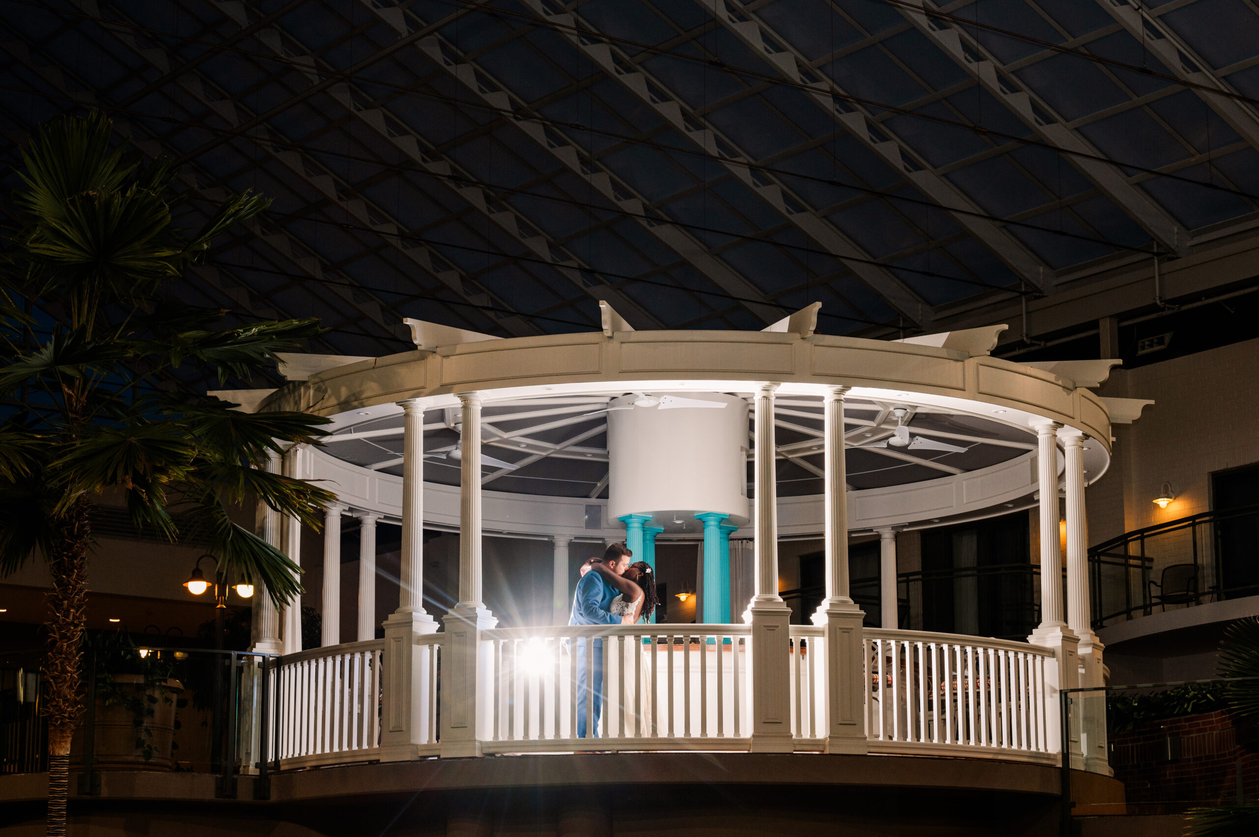 a photo of a bride and groom lit up inside a white gazebo at night. used in a blog post comparing honeybook to unscripted