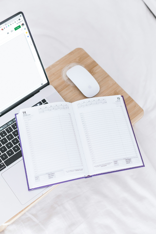 a notebook and a laptop used in a blog post about a new wedding timeline template