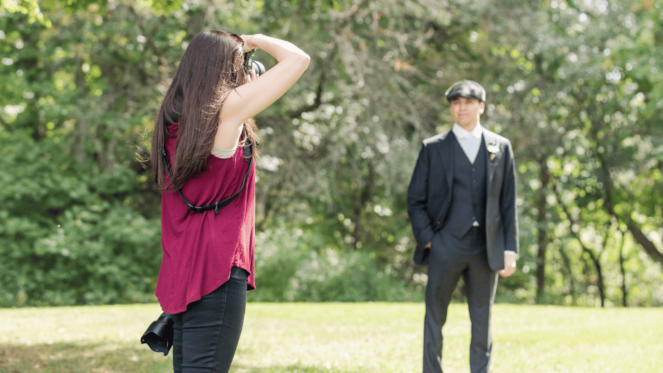 a wedding photographer takes a photo of a groom standing in the distance. photo is used in a blog post about running a business with a chronic illness. Photo by life is beautiful photography
